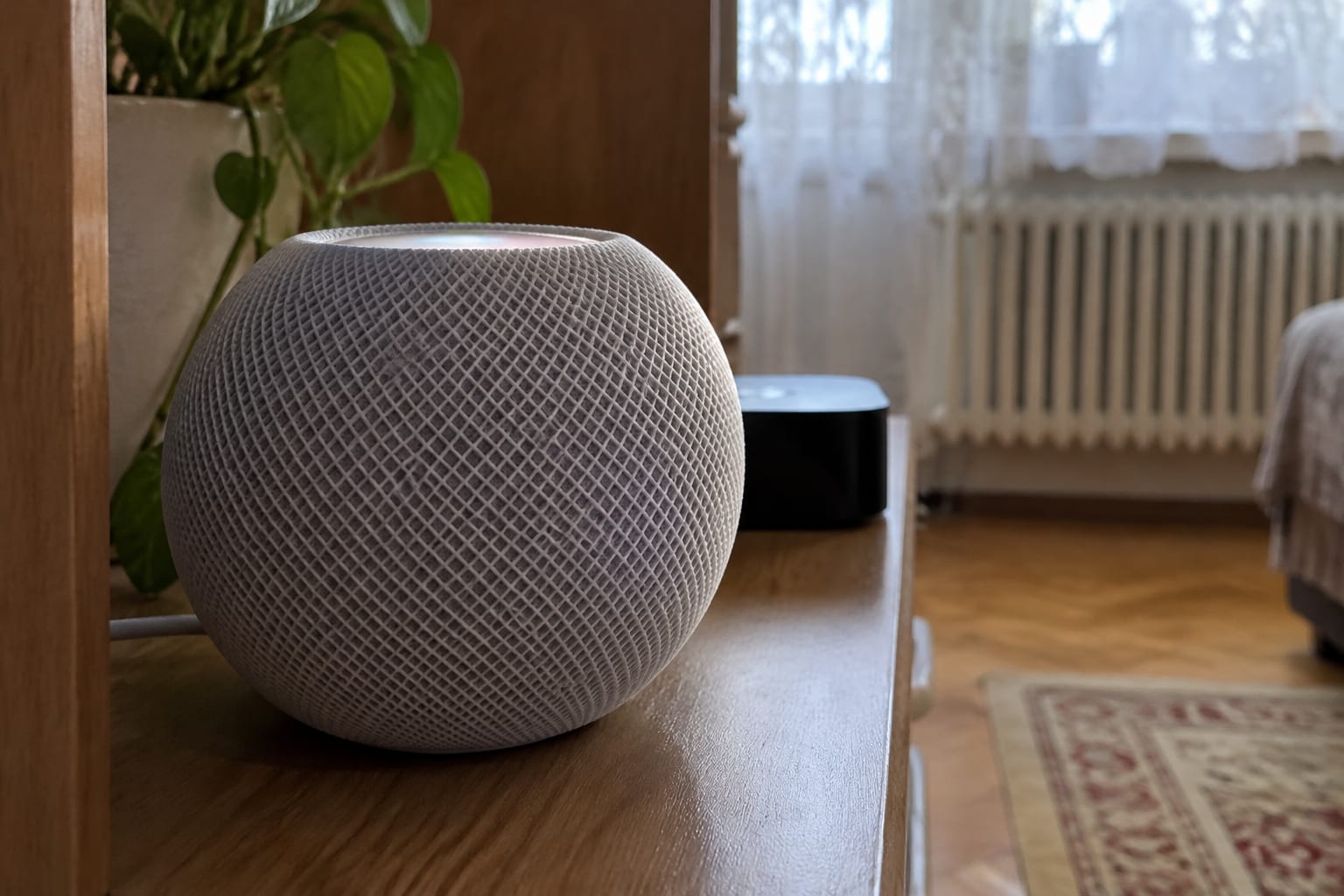 Boxă inteligentă HomePod mini pe comodă