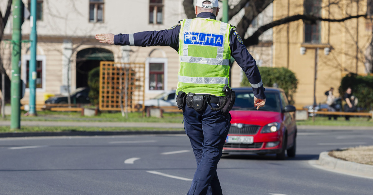 Polițist rutier dirijând circulația mașinilor pe o stradă din oraș